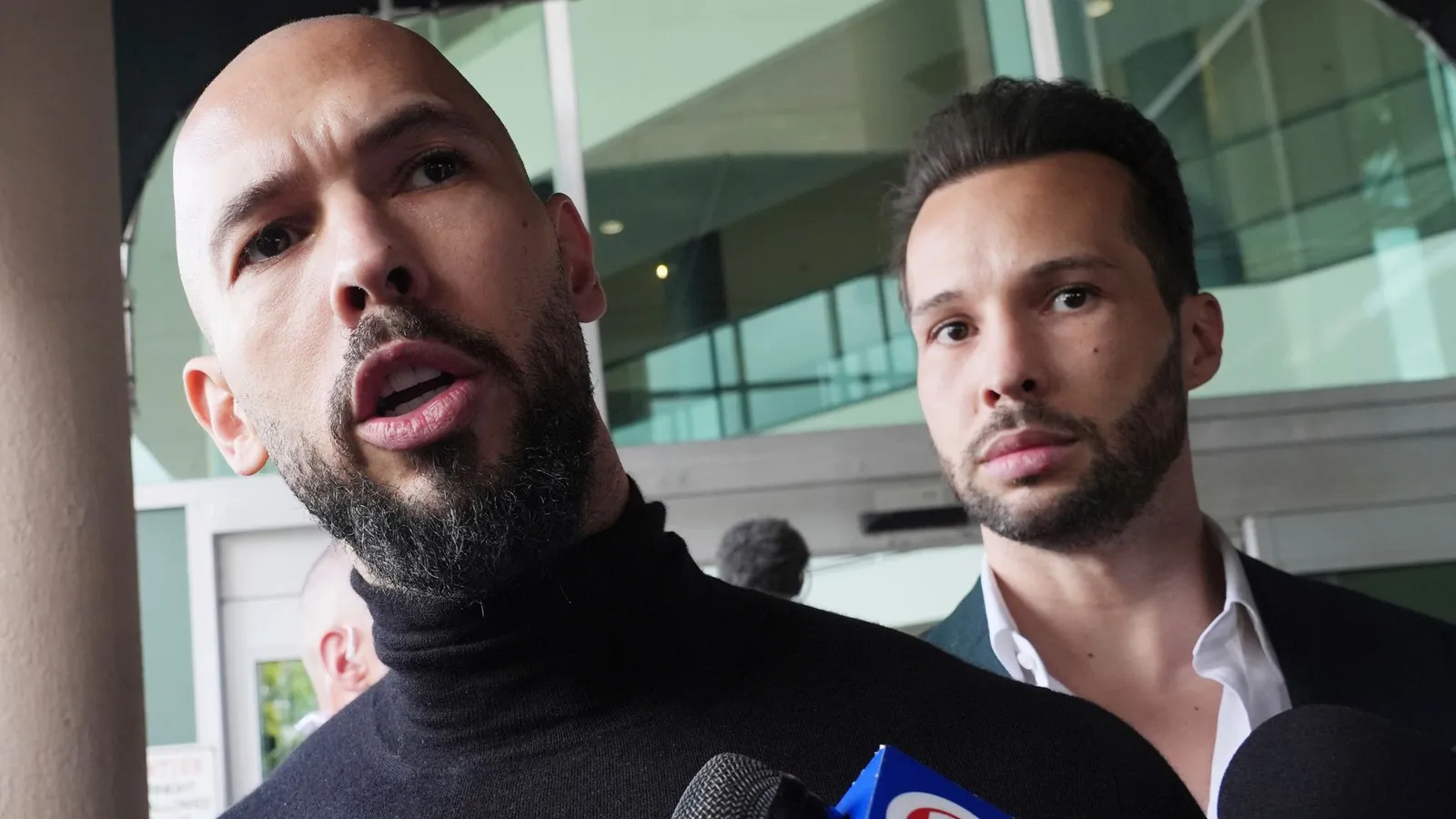 Andrew Tate and Tristan Tate speaking to reporters